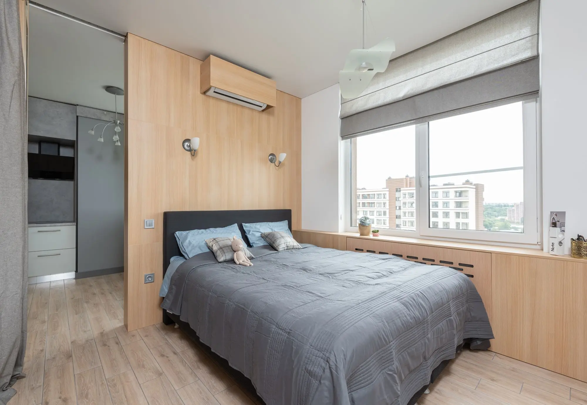 Split-Innengerät über dem Bett in einem hellen Schlafzimmer